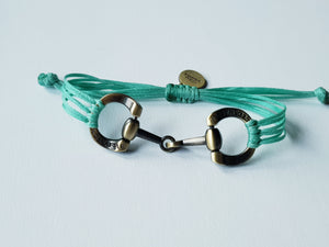 Brushed gold horse bit snaffle bracelet in leather string